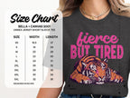 Unisex tee size chart with "fierce BUT TIRED" text and tiger graphic.