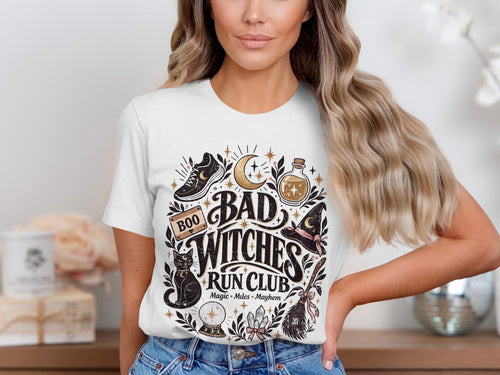 White t-shirt with "Bad Witches Run Club Magic Miles Mayhem" graphic.