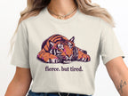 Cream t-shirt with a resting tiger graphic and "fierce. but tired." text.