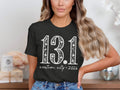 Dark t-shirt with white text reading "13.1 custom city * 2026".