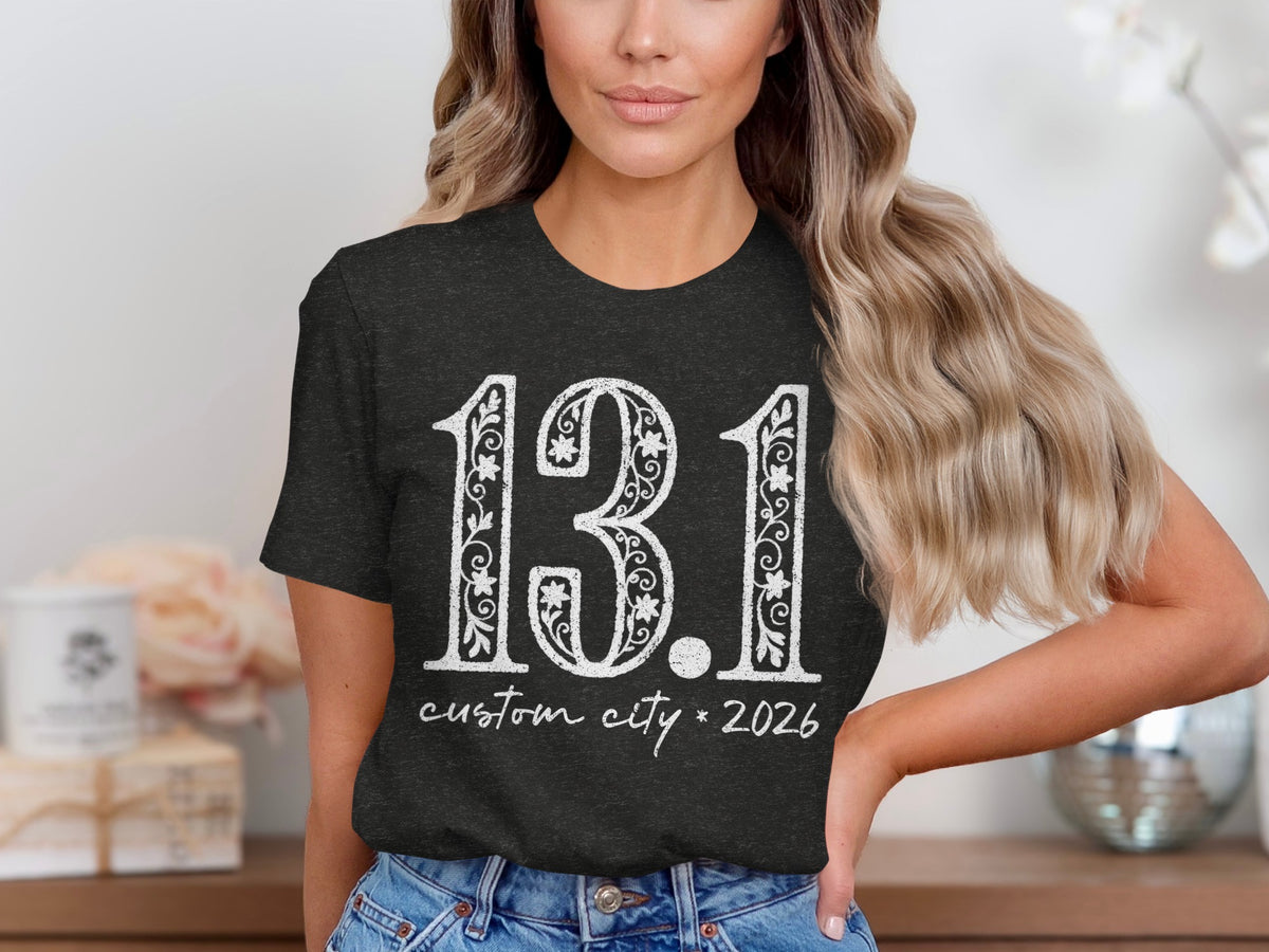 Dark t-shirt with white text reading "13.1 custom city * 2026".