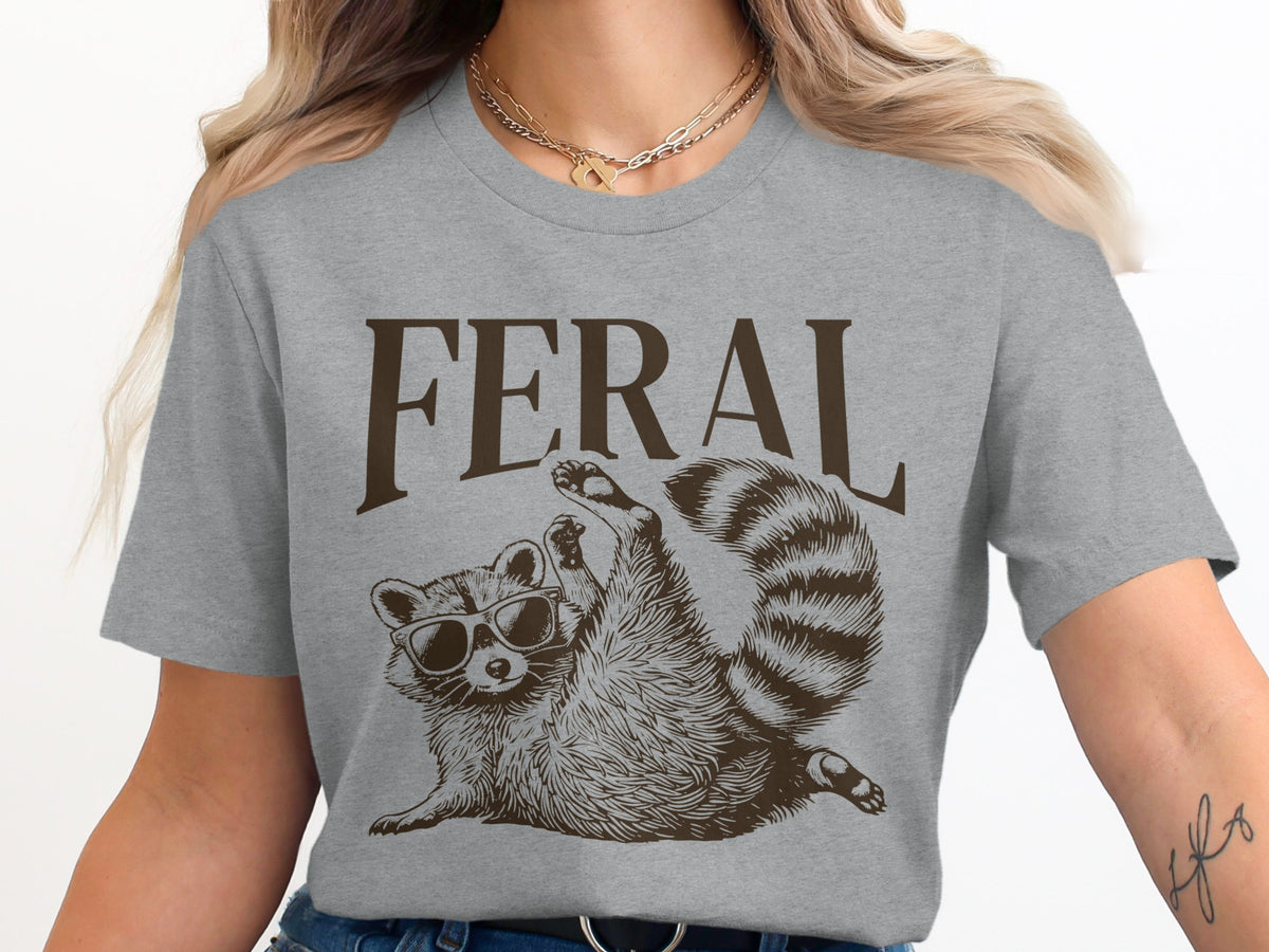 Grey t-shirt with brown "FERAL" text and raccoon wearing sunglasses.