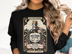 Black sweatshirt with "Delusion Elixir" design featuring a bottle, mountains, and warning text.