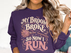 Purple sweatshirt with "My broom broke, so now I run" text and Halloween graphics.