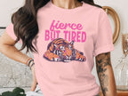Pink t-shirt with a tiger graphic and text "fierce BUT TIRED".