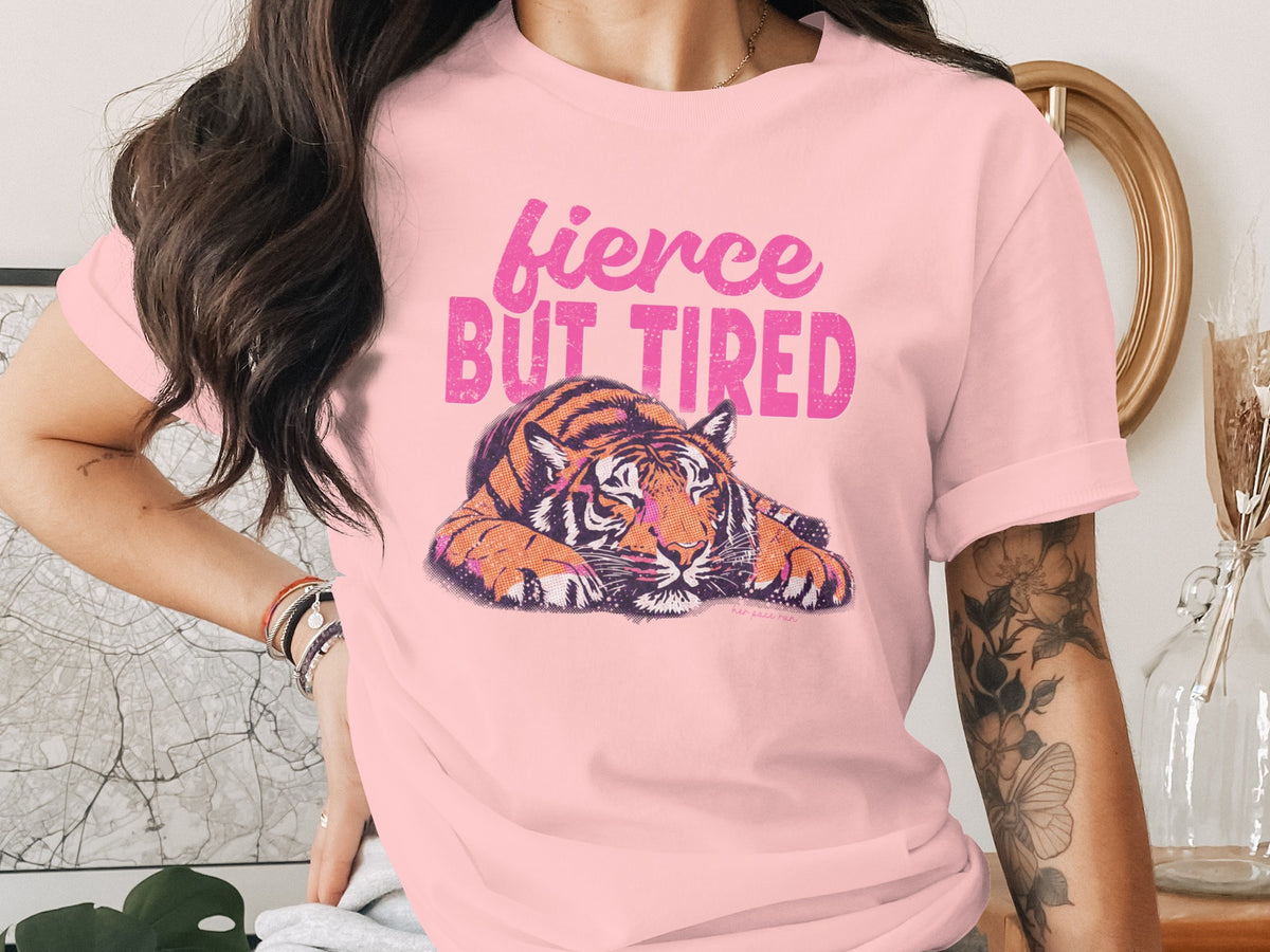 Pink t-shirt with a tiger graphic and text "fierce BUT TIRED".