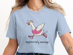 Light blue t-shirt with cartoon goose running, wearing pink outfit and text "aggressively average".