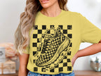 Yellow t-shirt with checkered graphic, shoe, and text about running.