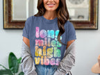 Blue t-shirt with "long miles high vibes" text in colorful tie-dye pattern.