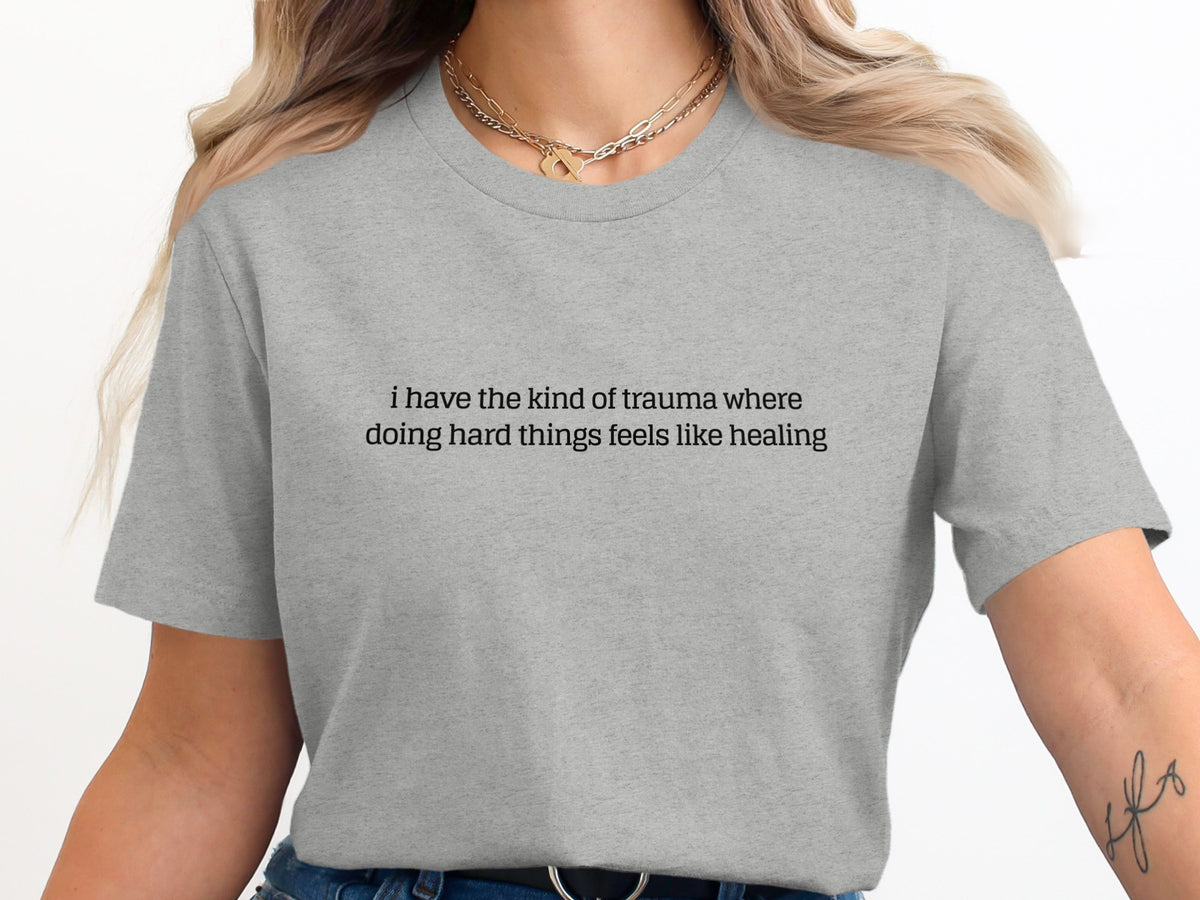 Gray t-shirt with text "i have the kind of trauma where doing hard things feels like healing"