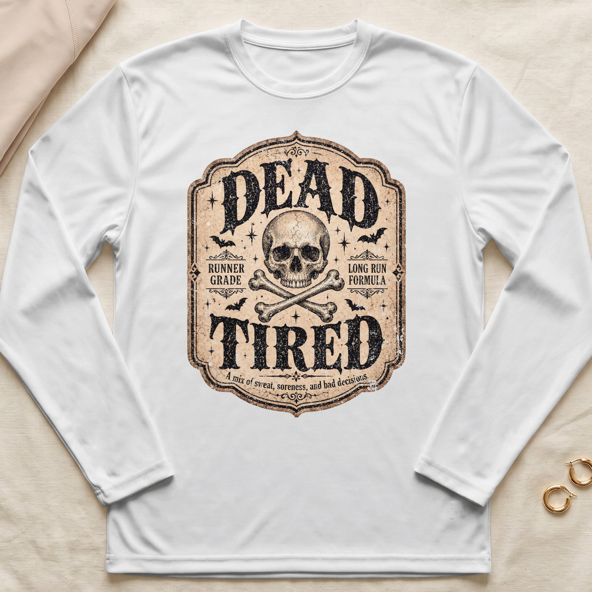 White long sleeve shirt with "DEAD TIRED" graphic, skull, bones, bats, and text.