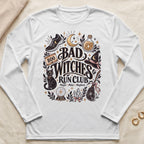 White long sleeve shirt with "Bad Witches Run Club" graphic featuring a cat, moon, and running shoe.