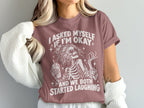 T-shirt graphic of a skeleton holding a drink, text reads "I asked myself if I'm okay and we both started laughing."
