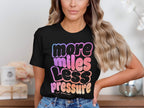 Black t-shirt with "more miles less pressure" text in gradient lettering.