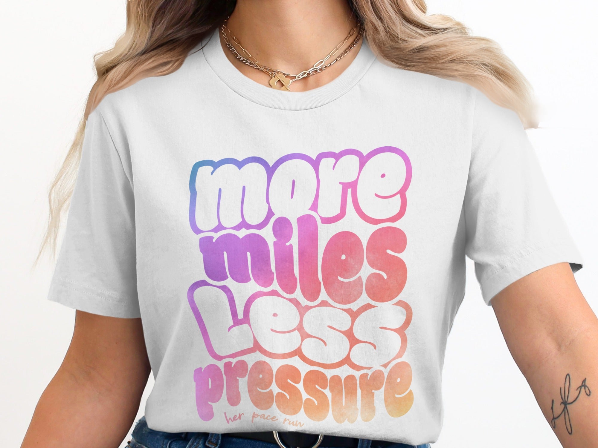 White t-shirt with gradient text reading "more miles less pressure" and "her pace run".