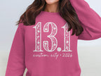 Pink sweatshirt with white "13.1" and "custom city * 2026" text.