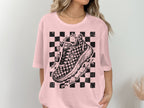 Pink t-shirt with checkered pattern and sketch of a running shoe.