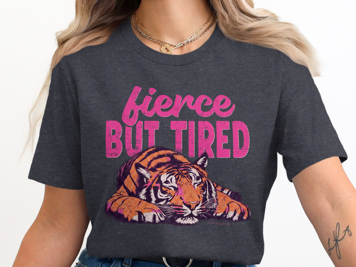 Dark grey t-shirt with "fierce BUT TIRED" text and a stylized tiger graphic.