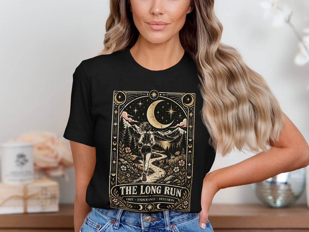 Black t-shirt graphic with a runner on a path under a crescent moon, text "The Long Run".