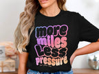 Black t-shirt with gradient text "more miles less pressure" and "her pace run".