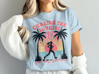 Light blue t-shirt with graphic of runner, palm trees, and text "Chasing the Sunrise" and "good days start here".