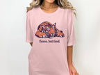 Pink t-shirt with a lounging tiger graphic and text "fierce. but tired."