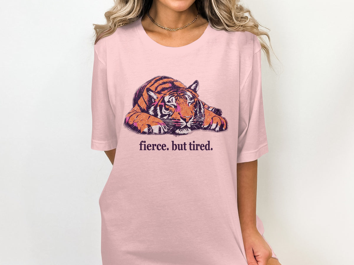 Pink t-shirt with a lounging tiger graphic and text "fierce. but tired."