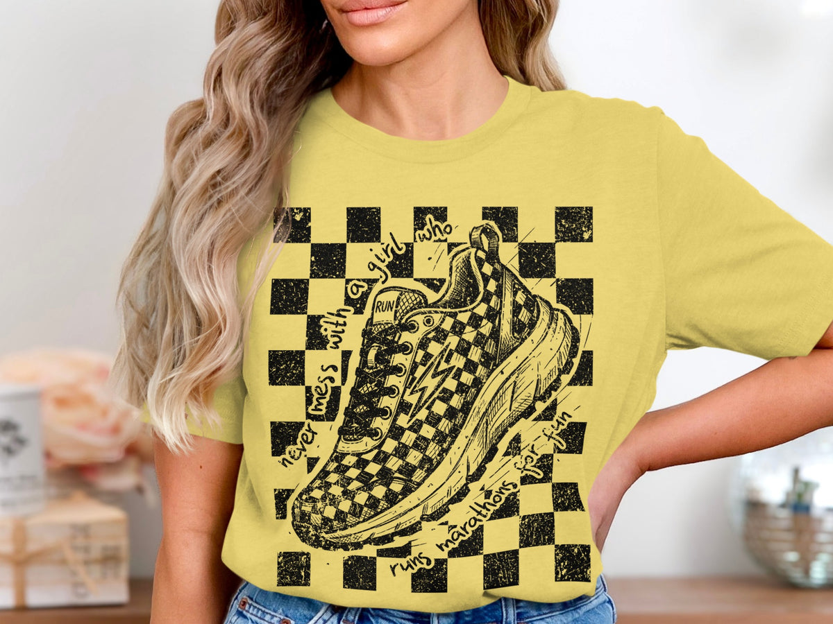 Yellow t-shirt with a checkered background and sketch of a running shoe.