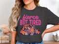 Charcoal t-shirt with "fierce BUT TIRED" text and a lounging tiger graphic.