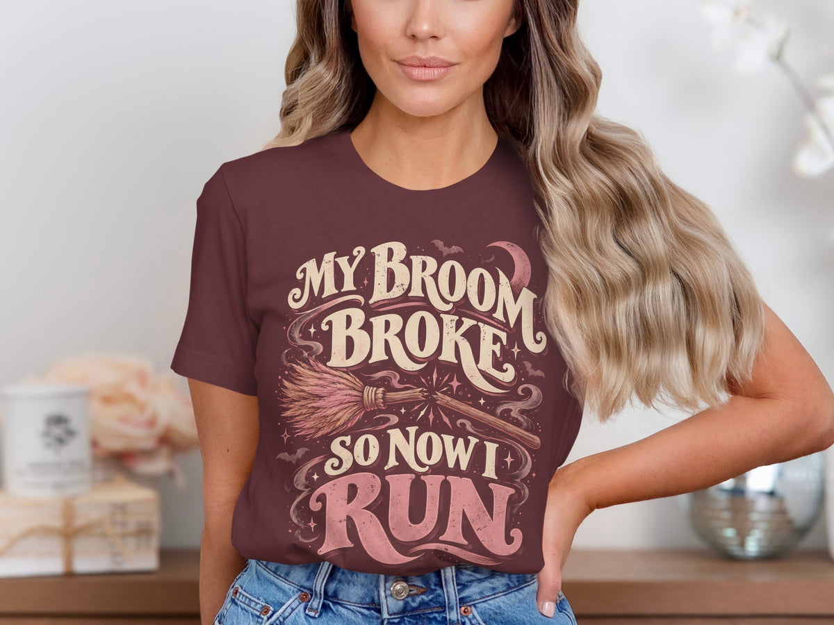 Burgundy t-shirt with "My broom broke so now I run" and witch broom graphic.