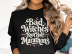 Black crewneck sweatshirt with "Bad Witches Run Half Marathons" text and pink accents.
