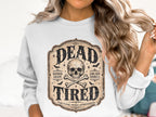 White sweatshirt with "DEAD TIRED" text, skull, crossbones, bats, and runner-themed phrases.