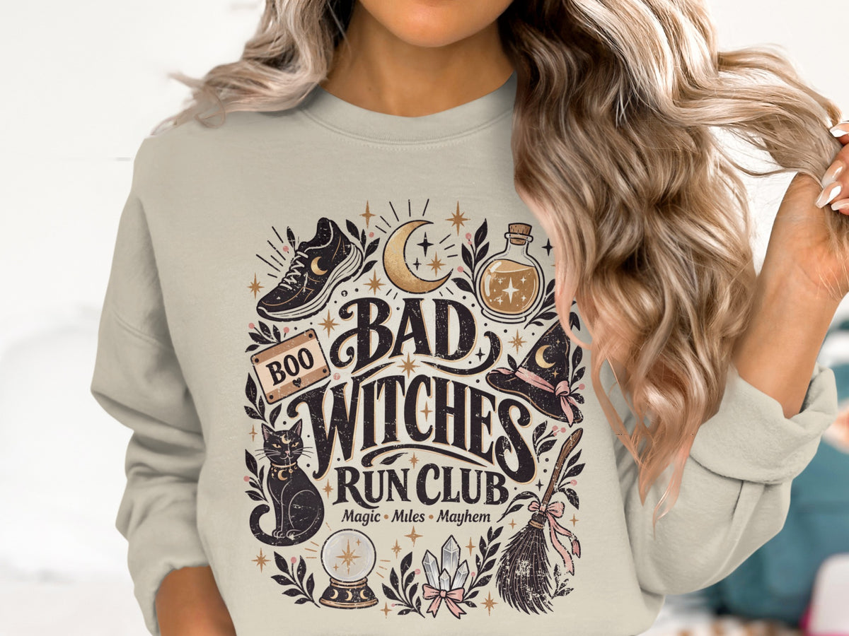 Crewneck sweatshirt with "Bad Witches Run Club" graphic and Halloween-themed illustrations.