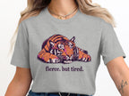 Grey t-shirt with a stylized tiger graphic and the text "fierce. but tired."