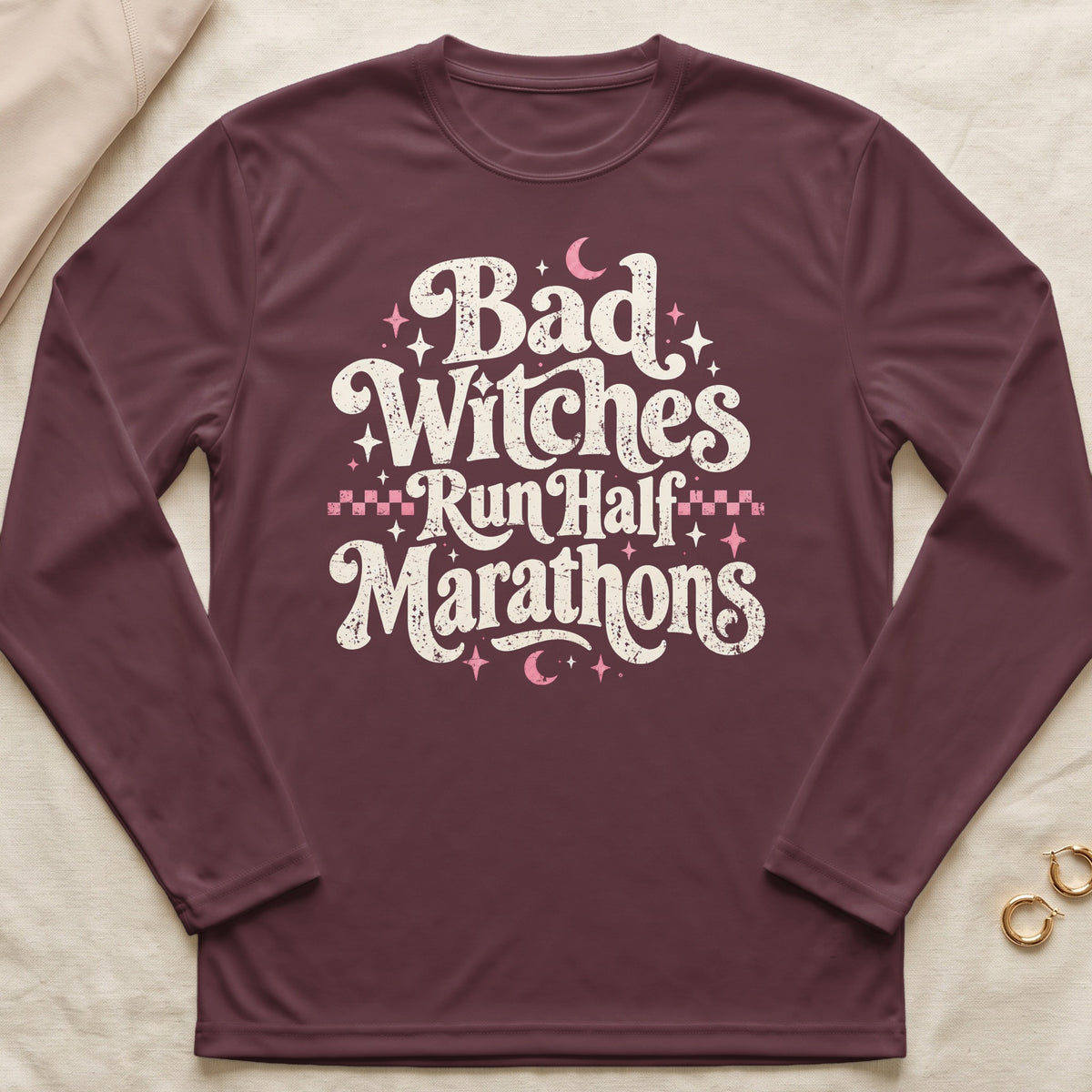 Maroon long-sleeve shirt with "Bad Witches Run Half Marathons" text and celestial graphics.