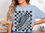 T-shirt with checkered pattern, running shoe graphic, and text.