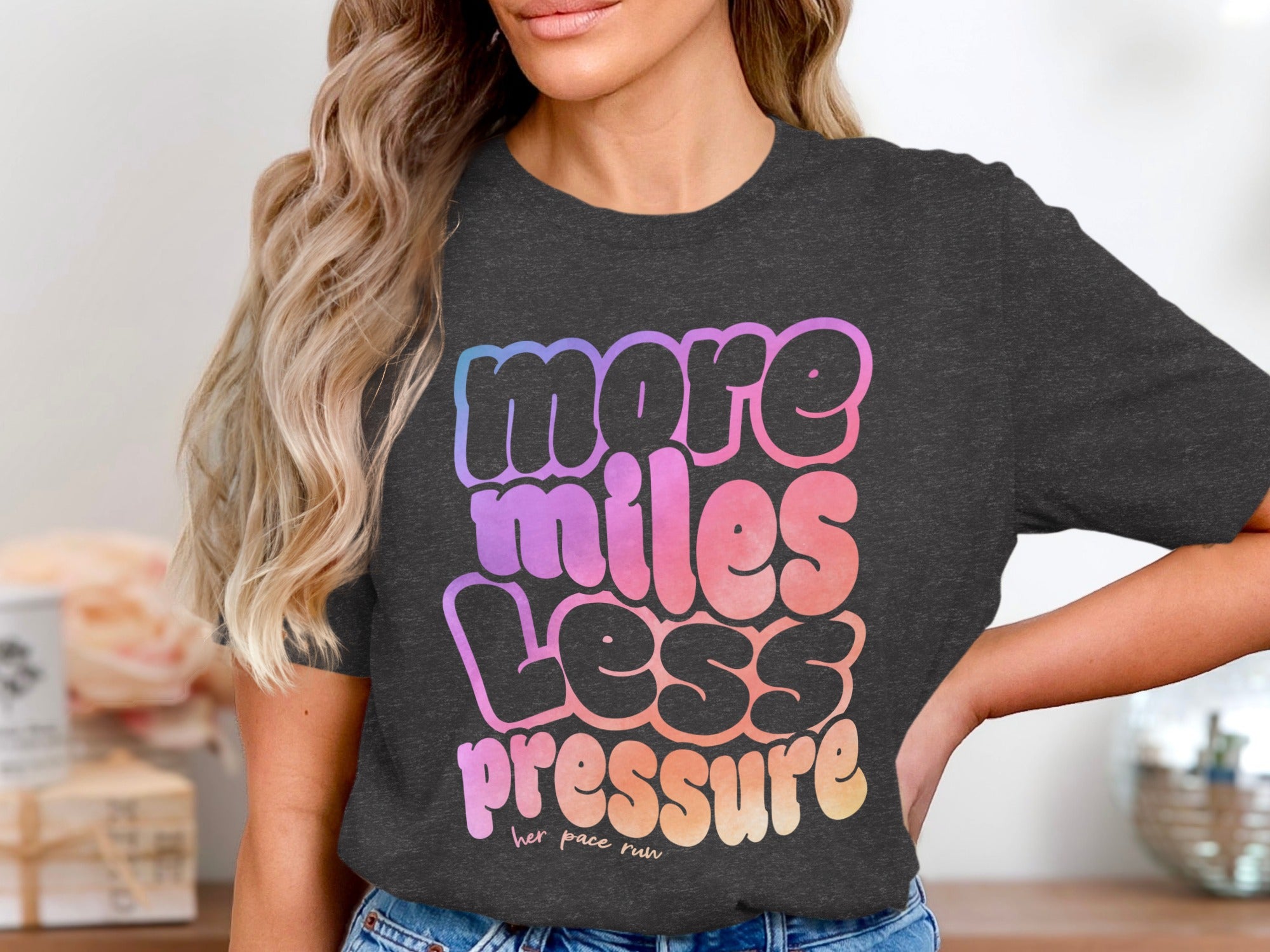 Dark gray t-shirt for women with a gradient graphic that says "more miles less pressure"