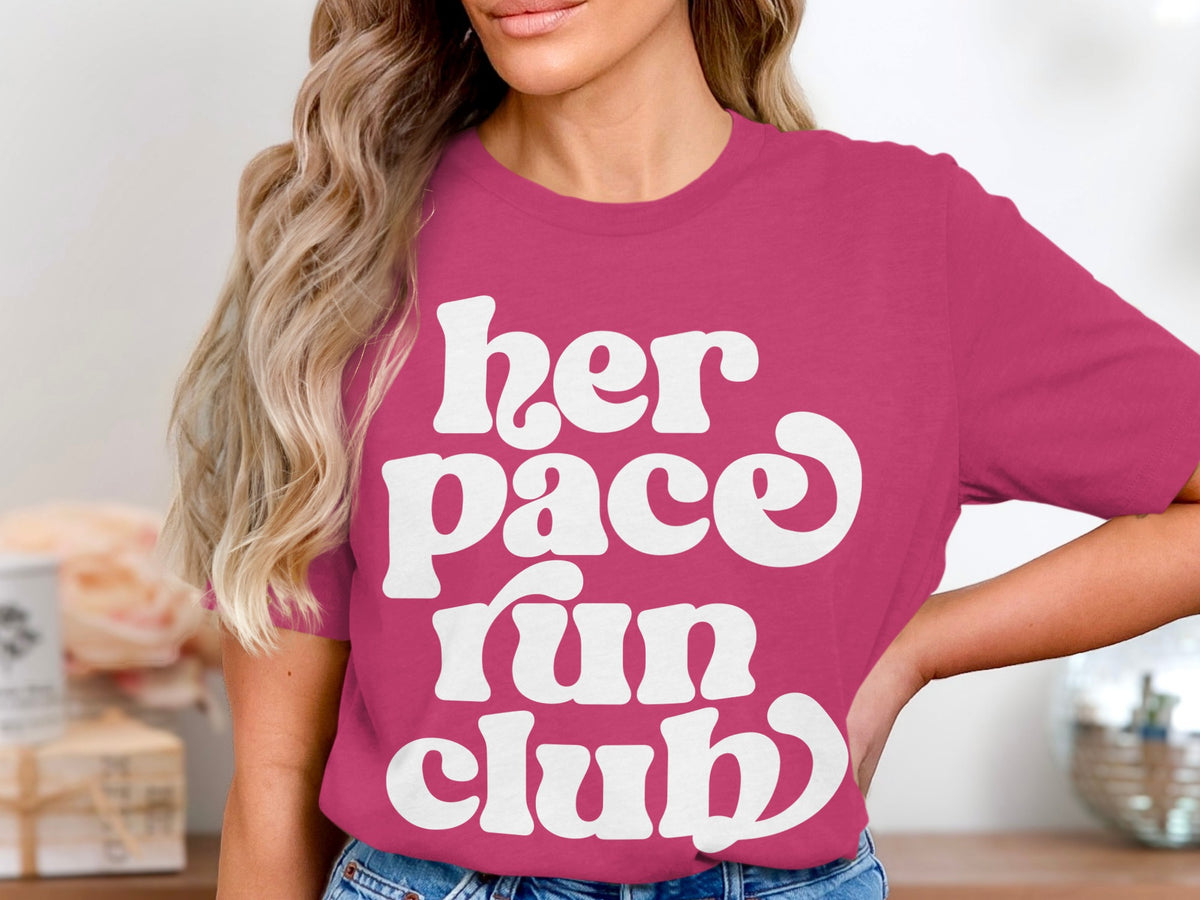 Pink t-shirt with white text "her pace run club".