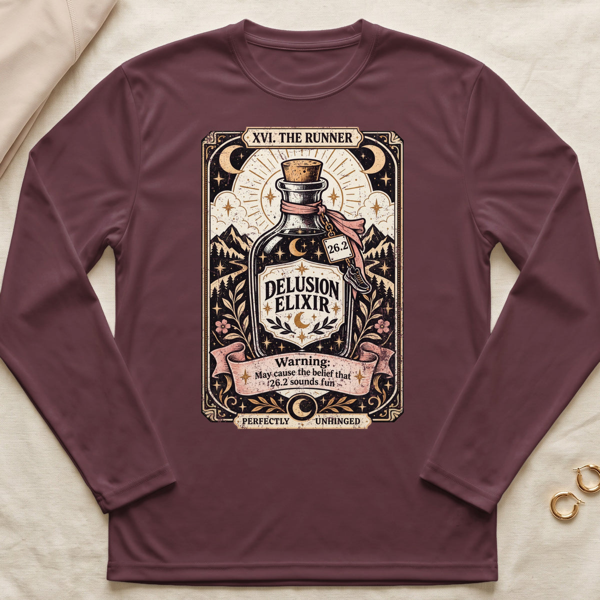 "Delusion Elixir" design with marathon runner theme on a maroon long-sleeved shirt.