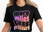 Black t-shirt with "more miles less pressure" text in gradient colors.
