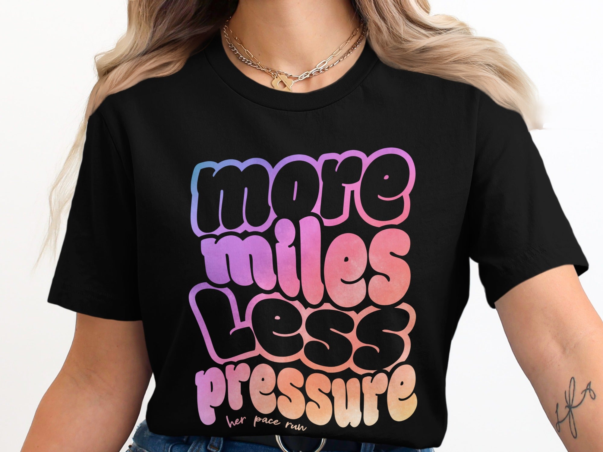 Black t-shirt with "more miles less pressure" text in gradient colors.