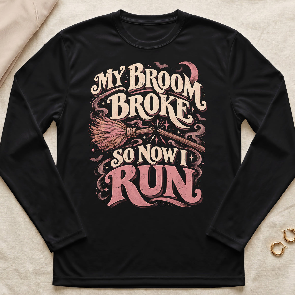 Black long sleeve shirt with "My broom broke so now I run" Halloween graphic.