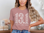 Rose t-shirt with white "13.1 custom city * 2026" text.