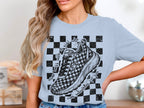 Light blue t-shirt with black checkerboard pattern and running shoe graphic.