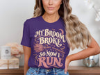 Purple t-shirt with text "My broom broke so now I run" and Halloween graphics.