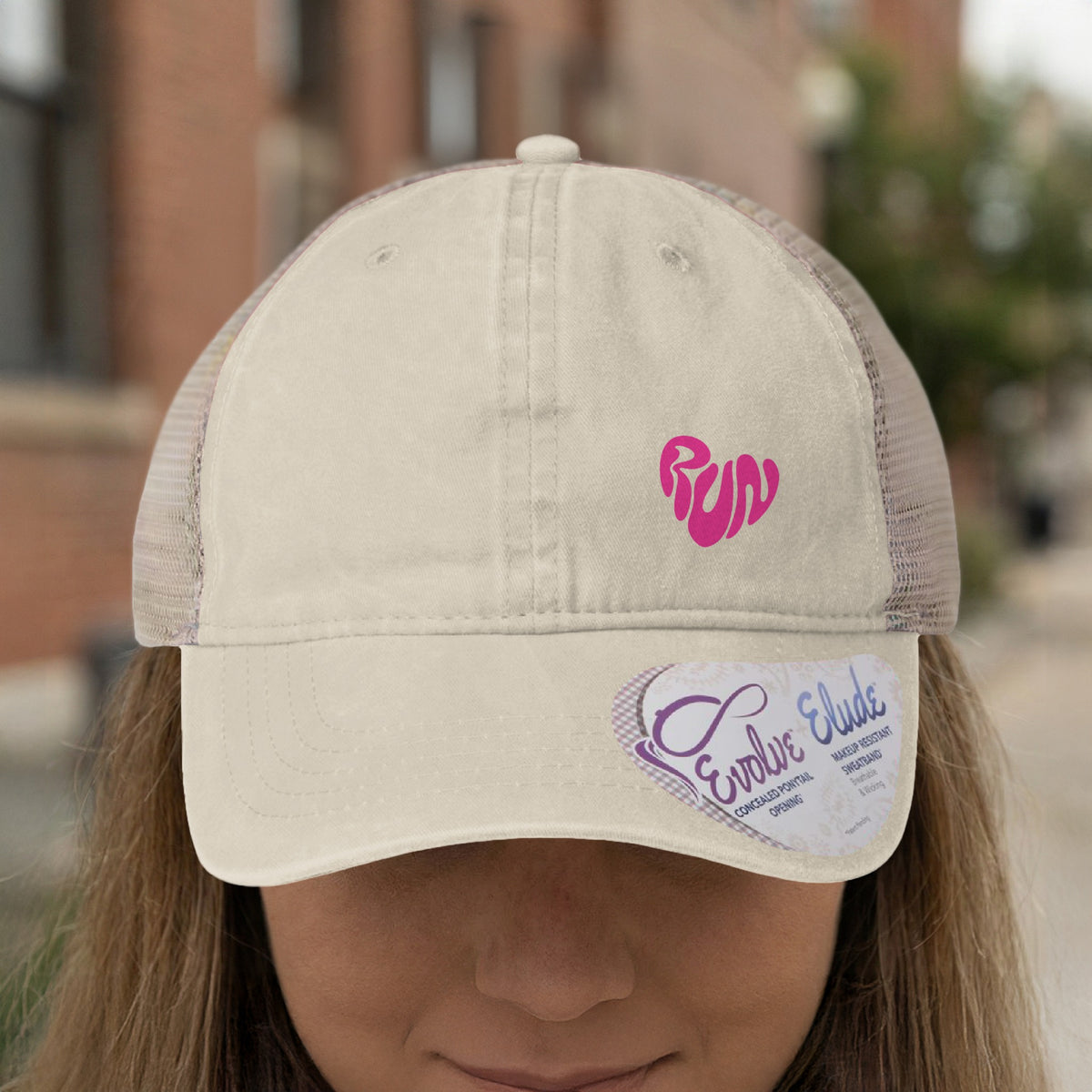 Cream trucker hat with pink "run" heart logo and heart-shaped tag.