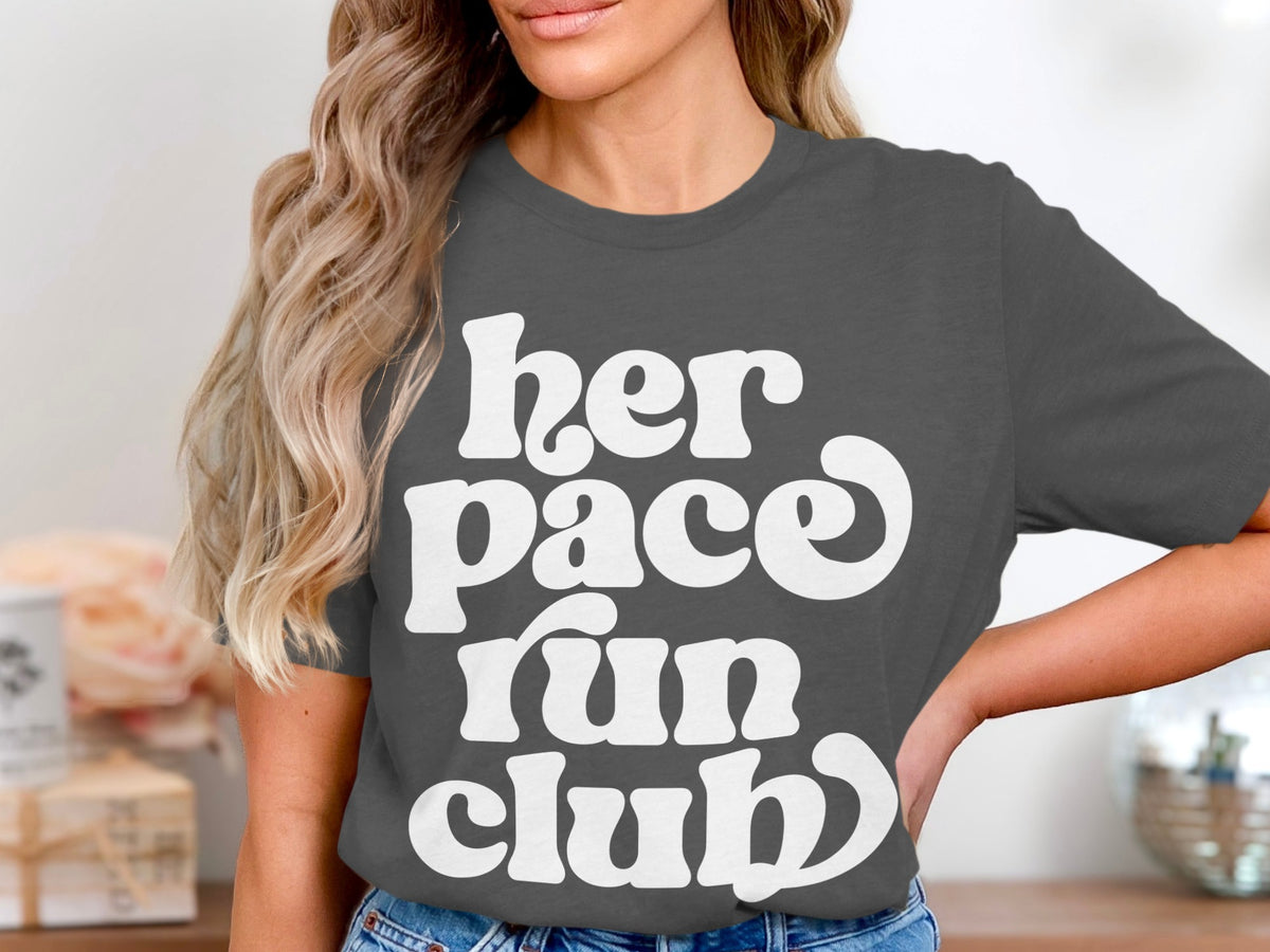 Dark gray t-shirt with white text reading "her pace run club".