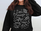 Black sweatshirt with white text and running-themed graphics: "I'm nicer after my run."