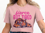 Pink t-shirt with a graphic of a tiger and text "fierce BUT TIRED".
