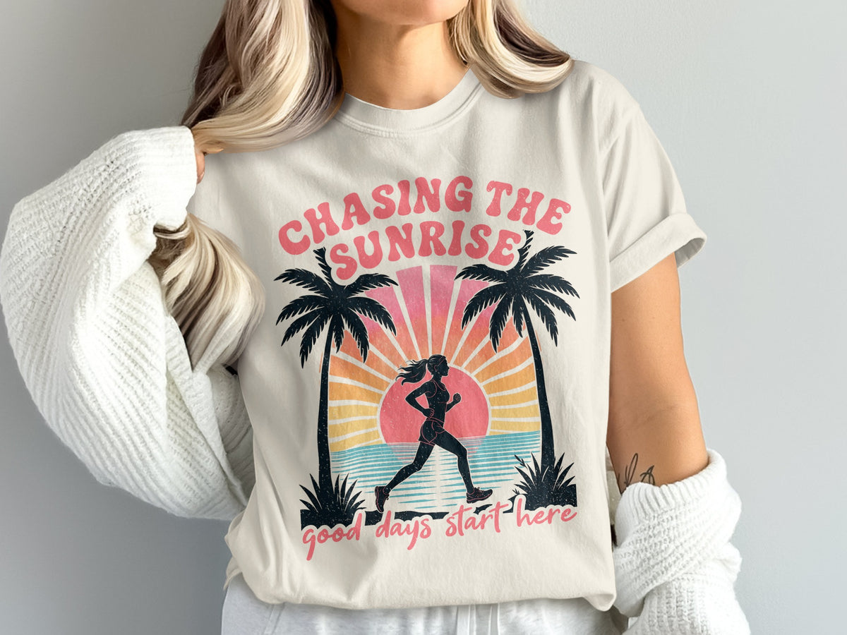 T-shirt graphic with runner, palm trees, sunrise, ocean, and text.